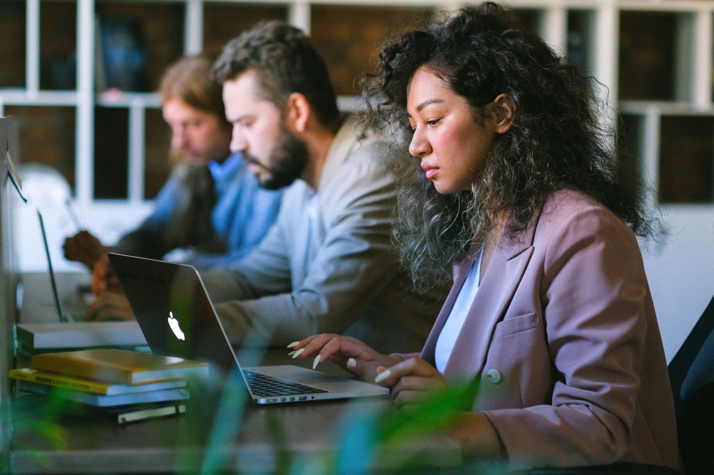 Focused professionals collaborating on laptops in a modern office